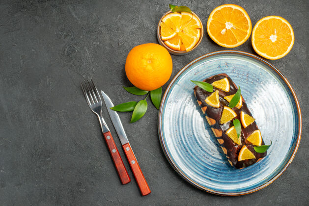 全套上图是一套黄色的全切橙子和美味的蛋糕放在深色的桌子上深色食物健康