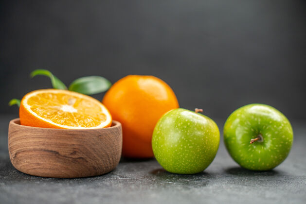 苹果在黑暗的桌子上有新鲜橙子和青苹果的水果沙拉的侧视图深色壁板酸橙