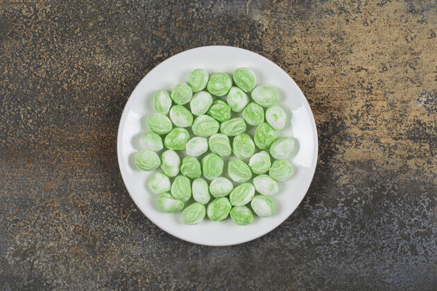 糖果白色盘子上的绿色薄荷醇糖果香料邦邦糖果