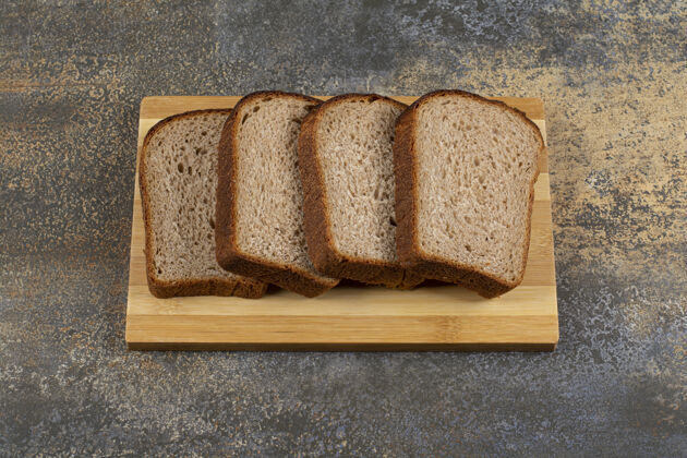 烤面包把新鲜黑麦面包片放在木板上面包新鲜黑麦