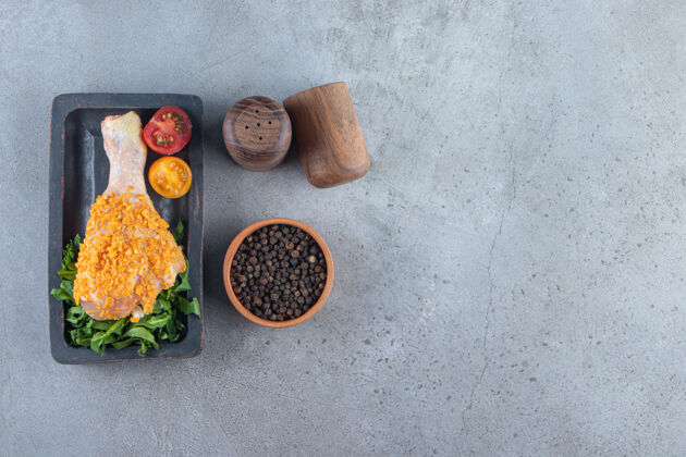 菜肴把腌好的鸡腿放在香料碗旁边的木板上 放在大理石背景上鸡滋养香料