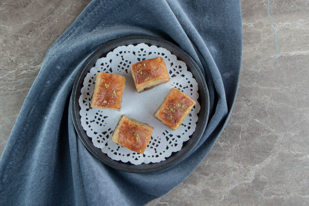 开心果四个美味的烤熔岩在黑暗的盘子里盘子甜点Baklava