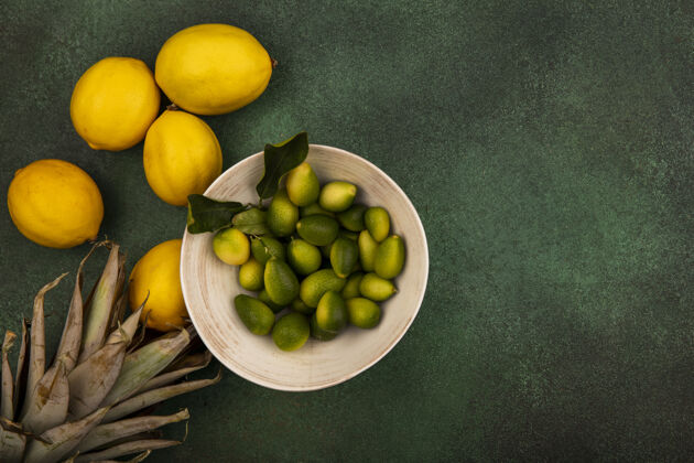 碗一个碗上的金盏花的顶视图 柠檬被隔离在一个绿色的表面上 有复制空间食物营养健康