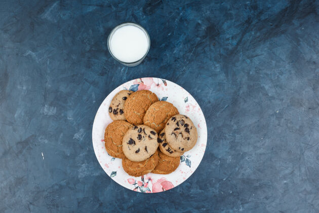 美味俯视图不同类型的饼干在深蓝色大理石背景上的牛奶花盘水平甜点薯条脆