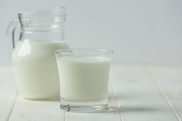 营养玻璃和牛奶瓶在白色的木头表面桌子木材自然