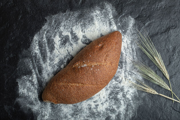 面包黑底新鲜出炉的黑麦面包烹饪休息烘焙