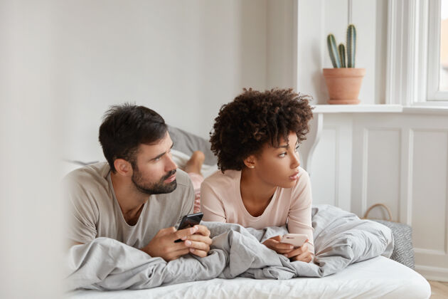 信息沉思的家庭夫妇使用蜂房 集中在一边 早上躺在床上应用程序家庭男朋友