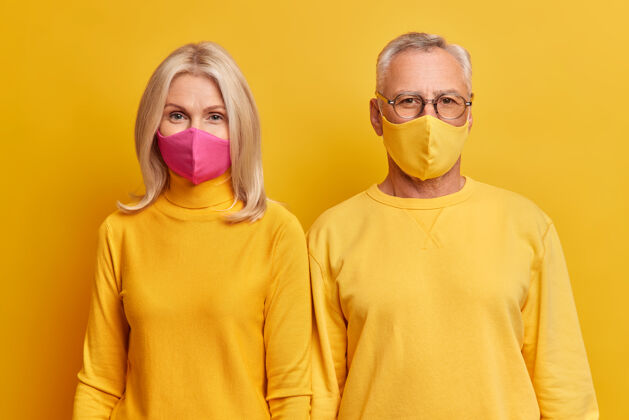 毛衣老两口站得很近 隔离期间呆在家里戴防护面罩 穿黄色衣服 认真看前面夫妻流感金发