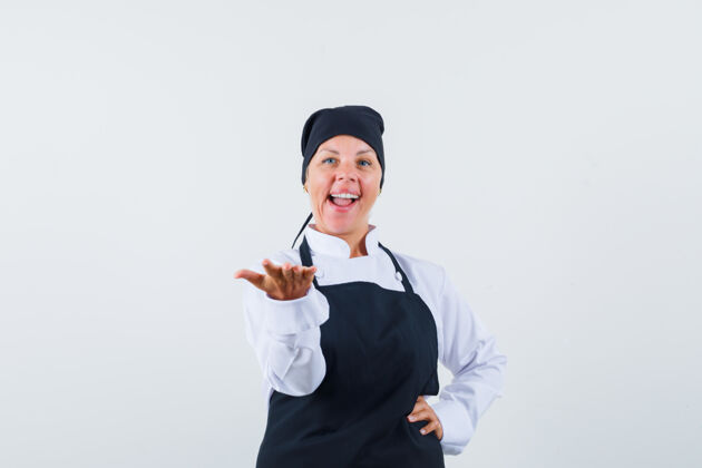 女性女厨师伸出手 呈现出制服 围裙和自信的样子 正面视图手女人伸展