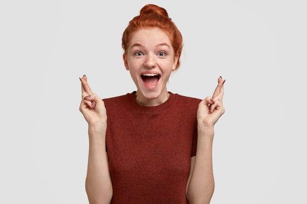 相信积极的人类情感观快乐的满脸雀斑的红发女孩从快乐中张嘴 交叉手指手势T恤情绪
