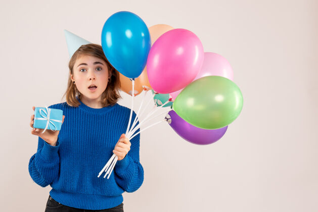 年轻女性手持彩色气球和白色小礼物的年轻女性气球聚会生日
