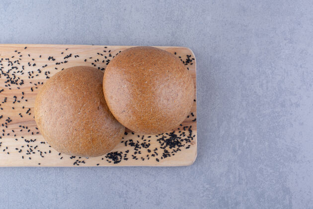 面粉在大理石表面用黑芝麻和汉堡包做成的木板汉堡包面团自制