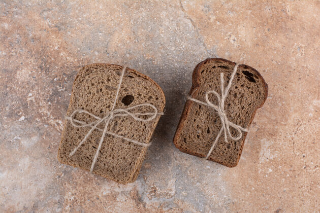 新鲜两种黑麦面包堆在大理石背景上绳索谷类面包