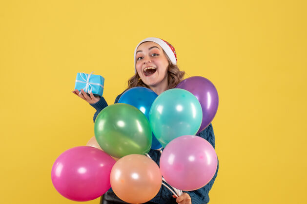 生日手持小礼物和黄色气球的年轻女性乐趣聚会年轻女性