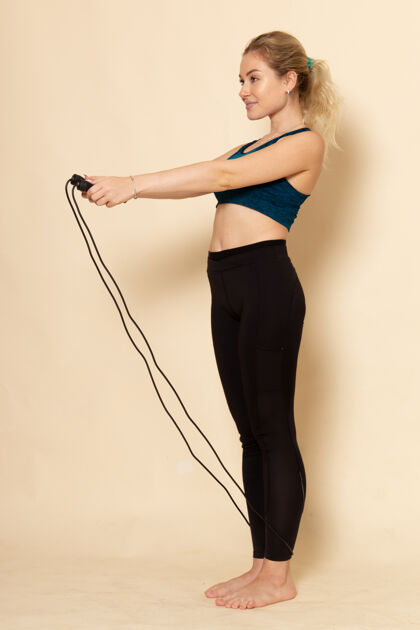 锻炼正面图穿着运动服的年轻女性正在跳绳练习模特时尚年轻女性