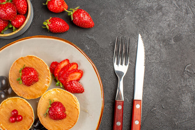 过滤器顶视图小美味的薄饼与水果在深灰色的表面馅饼蛋糕水果草莓甜点饮食