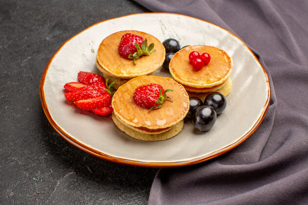 营养品正面是美味的薄煎饼 橄榄和水果放在深色的水果蛋糕上食物草莓景观