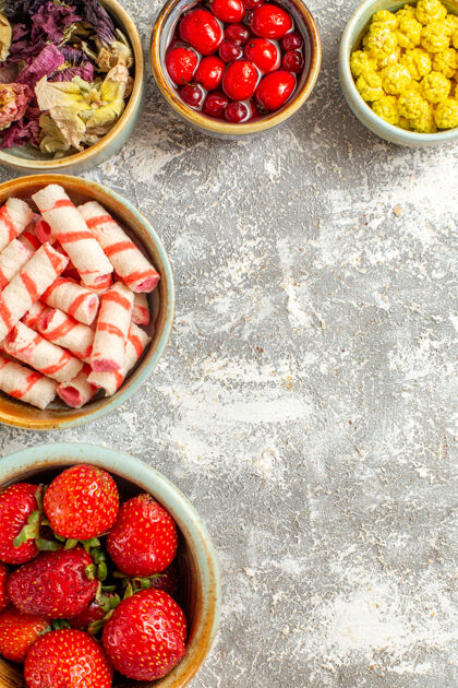托盘顶视图新鲜的红色草莓和糖果上的白色表面浆果红色糖果浆果草莓可食用水果