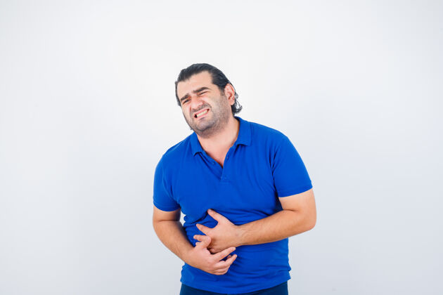 前面身穿蓝色t恤的中年男子胃痛难忍 面容不适 正面照医学年龄发烧