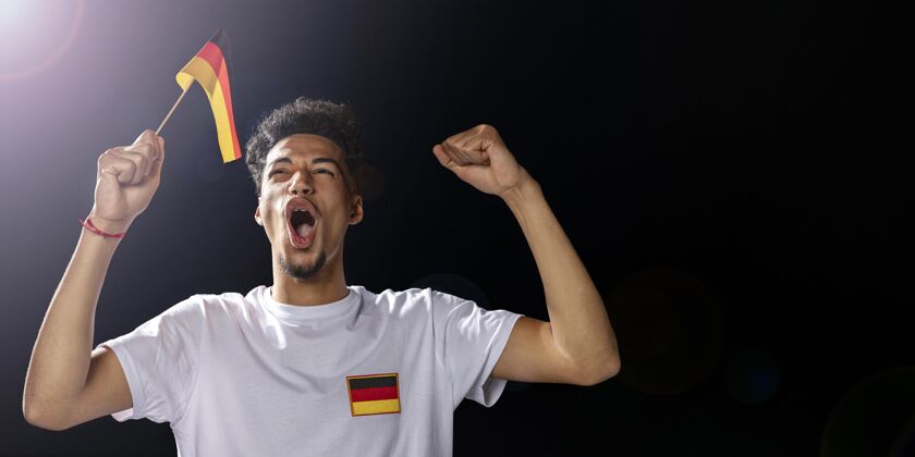 足球比赛手持德国国旗的啦啦队队员的正视图人人足球比赛