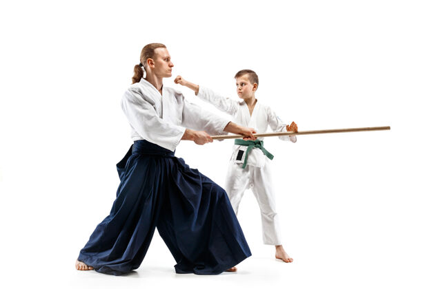 裙子男子和少年男孩在武术学校的合气道训练中用木剑搏斗日本人木头