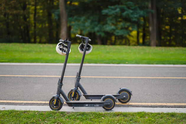 Escooter两辆电动滑板车停在公园的路边未来夏天环保
