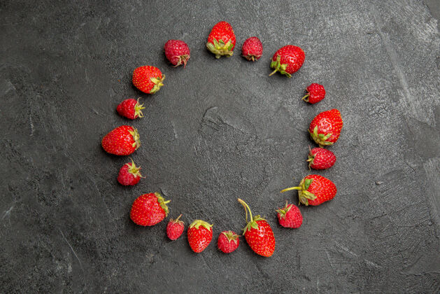 版面顶视图新鲜的红色草莓衬在深灰色的桌子上 颜色是浆果健康香草顶