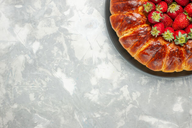 糖浅白色桌子上美味的草莓派和新鲜的红色草莓的俯视图酱汁午餐美味