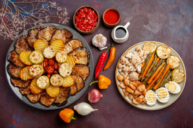 生的俯瞰美味的烤蔬菜土豆和茄子在深色背景上烤箱烹饪烤蔬菜的颜色烹饪烘焙餐厅