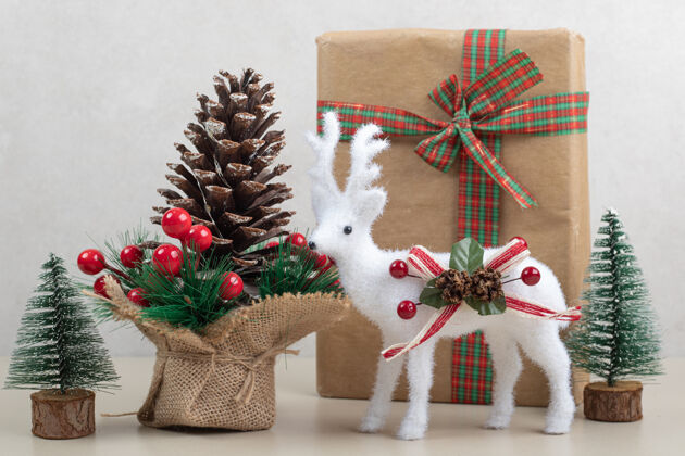 玩具白色表面有纸盒和装饰的圣诞玩具盒子弓松果