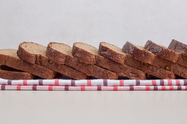膳食把新鲜的棕色面包片放在桌布上新鲜营养硬皮