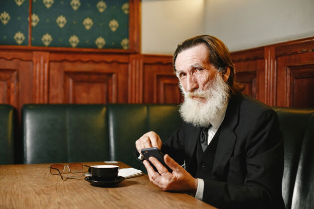 严肃有胡子的老商人喝咖啡的男人穿黑西装的大四学生手机咖啡馆电话