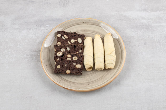 烘焙自制巧克力布朗尼和卷饼干放在盘子上 放在大理石桌上甜点自制饼干