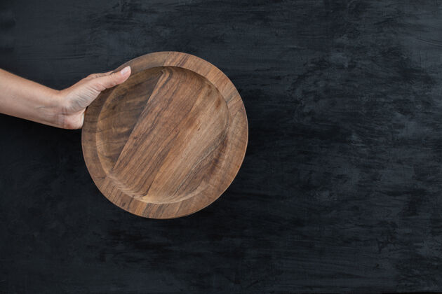 餐厅用手拿着一个圆形的木盘食物新鲜艺术