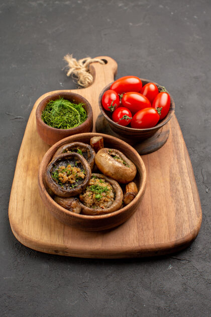 膳食正面图美味的熟蘑菇和新鲜的西红柿放在深色的桌子上成熟的野生食物美食健康蔬菜