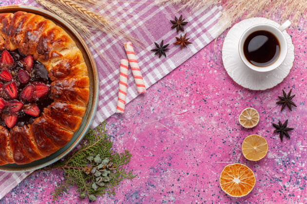 蛋糕俯瞰美味的草莓派水果蛋糕和一杯粉红色的茶桌子美味饼干