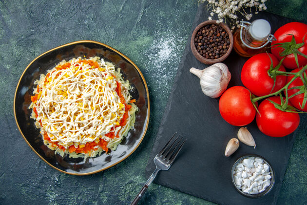 调味品顶视图含羞草沙拉在盘子里与调味品和深蓝色背景上的红色西红柿蓝色番茄红色