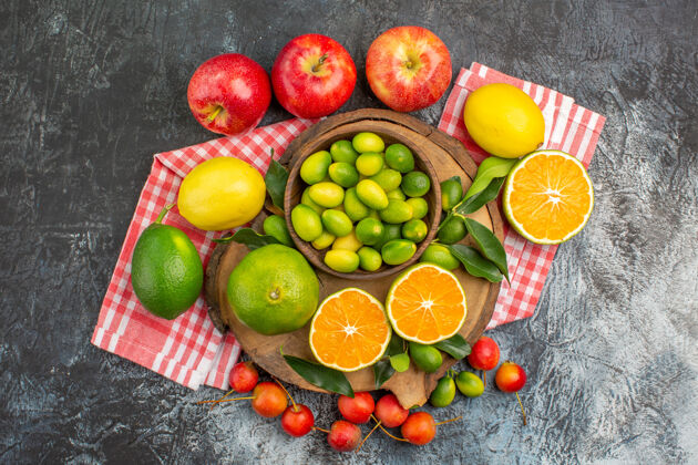 健康顶端特写查看柑橘水果柑橘水果在董事会樱桃苹果在桌布上苹果饮食柠檬