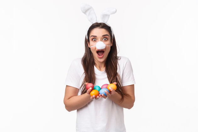 春天肖像富有表现力的年轻女子戴着兔子的耳朵和鼻子 手里拿着彩蛋年轻积极折扣