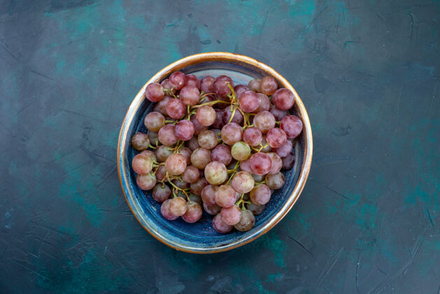 食物在蓝色的桌子上俯瞰新鲜葡萄 多汁和醇厚的水果盘子深色水果