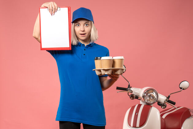 视图正面图：女快递员 带文件便条和咖啡 粉色工作服 工作服颜色持有文件专业