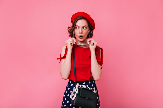 成人积极的白人女孩戴着可爱的红色贝雷帽 表达着兴趣室内照片是一位优雅的法国女模特 留着短发模特快乐美丽