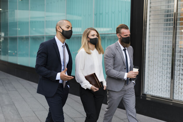 冠状病毒大流行戴着医用口罩的商务人士走向办公室新常态职业行政人员