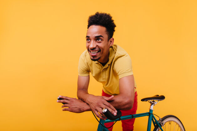 非洲穿着t恤的非洲帅哥在笑幽默的黑人男模和自行车合影的肖像家伙成人表情