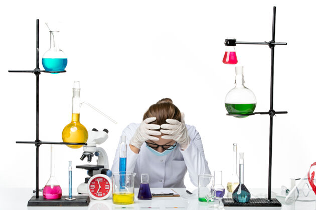 医疗前视图穿着医疗服的女化学家带着面罩坐在桌子前 在白色背景上感到疲惫病毒化学实验室病毒飞溅飞溅面具视图