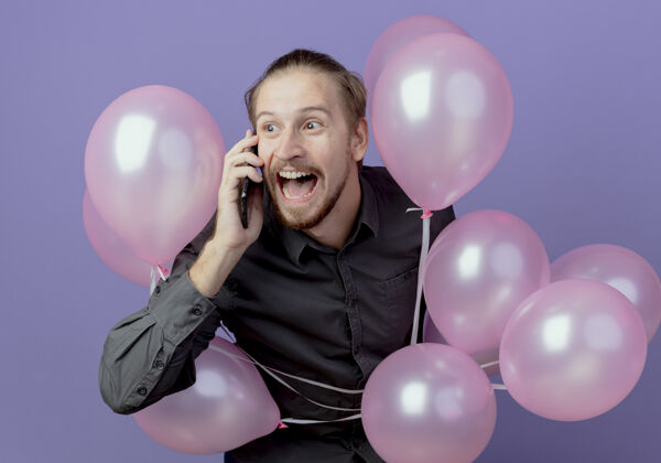 生日兴奋的帅哥拿着氦气球站在紫色的墙上讲电话男人站氦