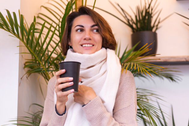 羊毛一个女孩在舒适的咖啡馆里用一杯热咖啡取暖坐着女人咖啡馆