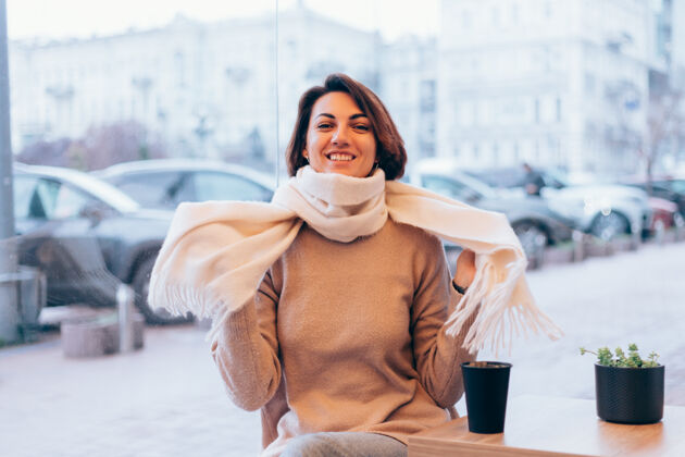 冷一个女孩在舒适的咖啡馆里用一杯热咖啡取暖冬天肖像女人