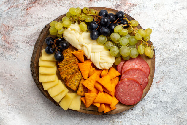 饮食顶视图不同的小吃cips香肠奶酪和新鲜葡萄在白色空间食品奶酪新鲜