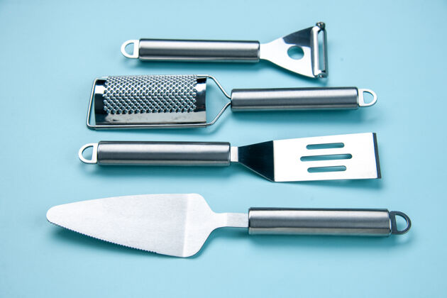 钢前视图不锈钢厨房工具躺在柔软的蓝色波浪背景与自由空间并排设备物体叉子